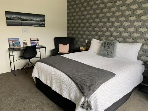 a bedroom with a large bed and a chair at Lakeview Terrace Accommodation in Cromwell