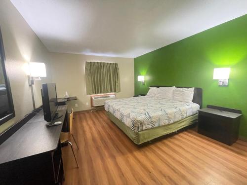 a hotel room with a bed and a flat screen tv at Dakota inn in Fargo