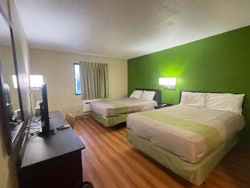 um quarto de hotel com duas camas e uma televisão de ecrã plano em Dakota inn em Fargo