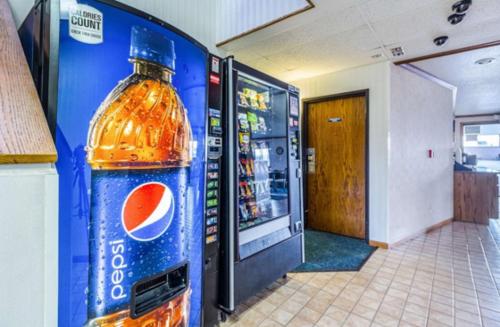 a large bottle of coke in a room with a refrigerator at Dakota inn in Fargo