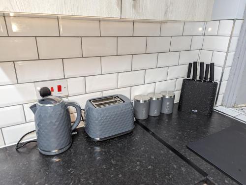 a counter top with a tea kettle and a toaster at cozy double rm9 in Oldham