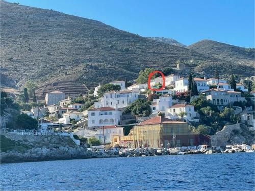 a group of houses on a hill with a red circle at Louisa’s View in Hydra