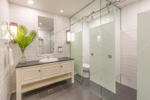 a bathroom with a sink and a glass shower at Grand Pacific Hotel in Suva