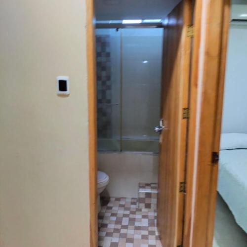 a door to a bathroom with a toilet and a shower at Alojamientos Fredys in El Socorro