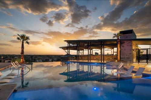 Una piscina con sillas y un edificio. en Home Sweet Home -San Antonio, en San Antonio