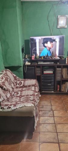 a bedroom with a tv and a bed in a room at Casa grande sossego in Contagem
