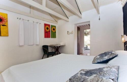 Dormitorio blanco con cama y mesa en Landhuis Daniel - Plantation House en Tera Kora