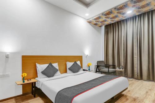 a hotel room with a bed and a chair at Collection O Hotel Landmark in Lucknow
