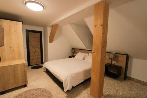 a bedroom with a bed with a wooden post at Am Fluss Saale in Weißenfels