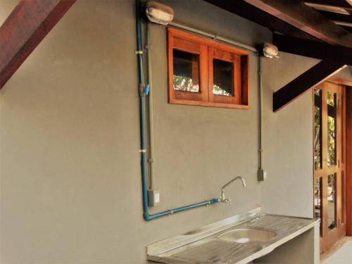 a kitchen with a sink and a window at Casa Caju em Imbassaí arejada tranquila e bem localizada para famílias e amigos in Imbassai