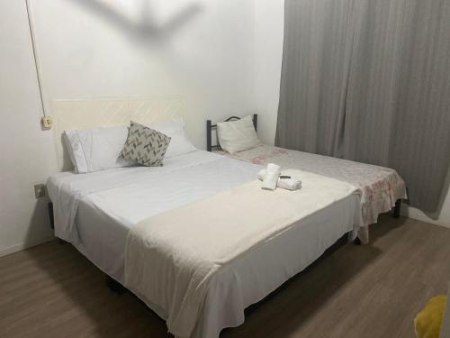 a bedroom with two beds with white sheets at Apartamento 03 br 290 restaurante Le Sorelle in Rosário do Sul