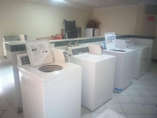 een wasruimte met witte wasmachines en wasmachines bij Tu hogar en la mitad del mundo. in Quito