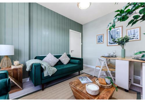 a living room with a green couch and a table at GREAT 4BR House in London