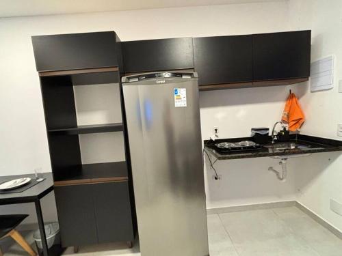 uma cozinha com um frigorífico de aço inoxidável e um balcão em Studio Santana 13 em São Paulo