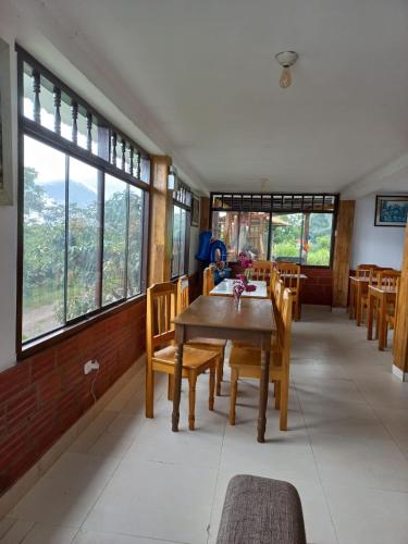 a dining room with a table and chairs and windows at Monte Gocta in Valera