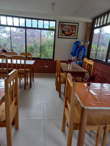 a restaurant with wooden tables and chairs and windows at Monte Gocta in Valera