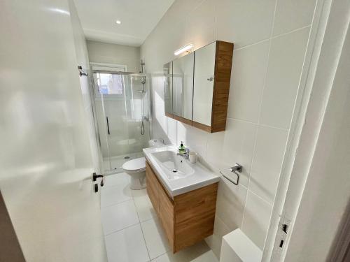 a bathroom with a sink and a shower and a toilet at Shiny Blue Apartment in Limassol