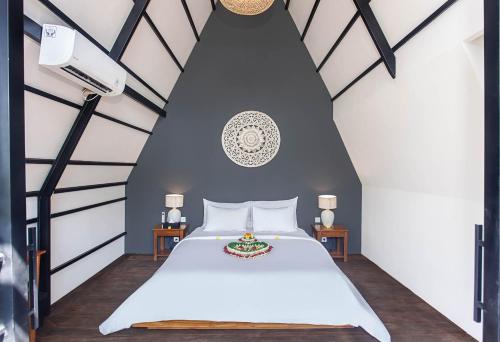 a bedroom with a white bed and two tables at IPIAN Angel by Pramana Villas in Ubud