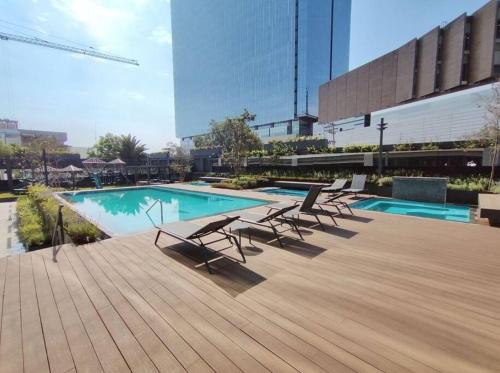a swimming pool with lounge chairs on a building at NSI Anseli in Mexico City