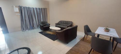 a living room with two chairs and a table at TIQ Homestay KLIA in Sepang