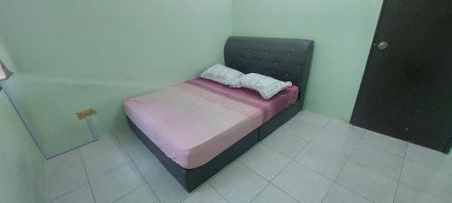 a small bed in a room with a purple mattress at TIQ Homestay KLIA in Sepang