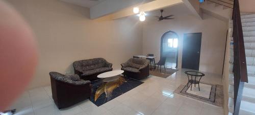 een woonkamer met 2 stoelen en een tafel bij TIQ Homestay KLIA in Sepang