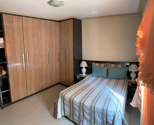 a bedroom with a bed and wooden cabinets at Casa Temporada Charres in Caparaó Velho