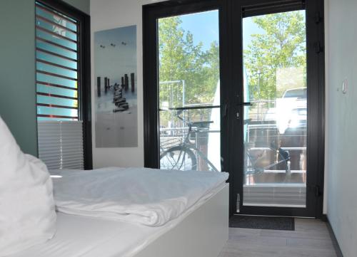 1 dormitorio con 1 cama y una ventana con una bicicleta al aire libre en Hausboot Albatros, en Mücheln