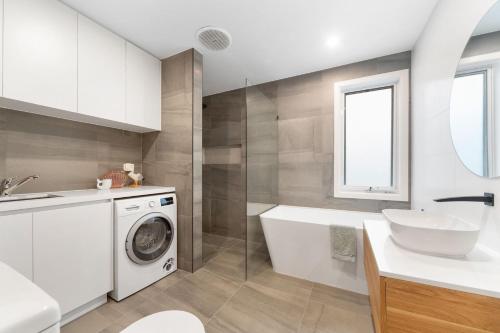 a bathroom with a washing machine and a sink at Secluded Seaside Hideaway in Rye