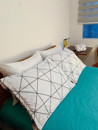 a bedroom with a bed with a black and white comforter at Bogotá Kings 300 in Bogotá