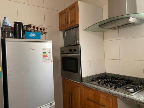 a kitchen with a refrigerator and a stove top oven at BBCasita Las Condes in Santiago