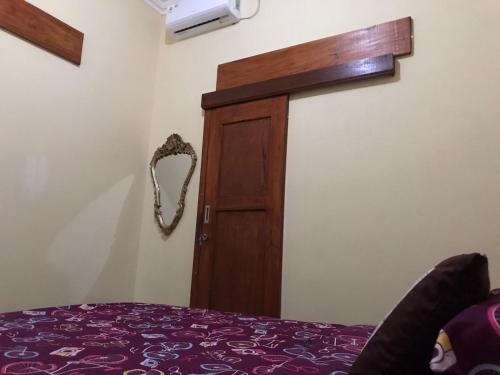 a room with a bed and a wooden door at Les Cantik Homestay in Tejakula
