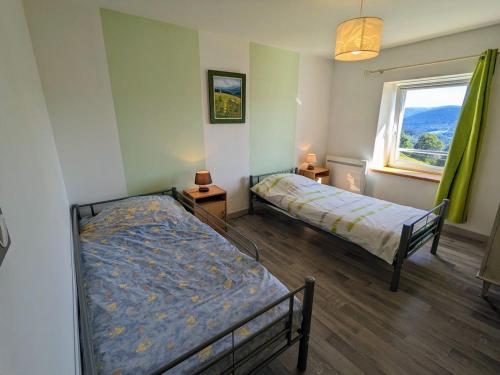 a bedroom with two beds and a window at Gîte familial à Cornimont avec Wifi et parking - FR-1-589-84 in Cornimont