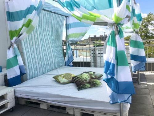 ein Bett auf einem Balkon mit einem Sonnenschirm in der Unterkunft VIP Design Apartment m. Dachterrasse in Dresden