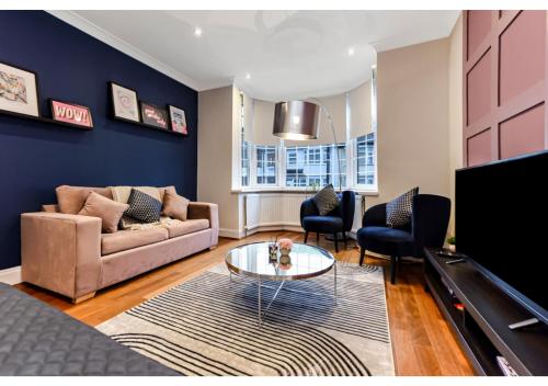 una sala de estar con un sofá y una mesa en Homey and Pleasant 3BD, en Londres