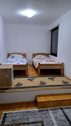 a room with two beds and a window at Apartmani Saraj in Sarajevo