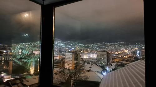 a view of a city at night from a window at Apartmani Saraj in Sarajevo