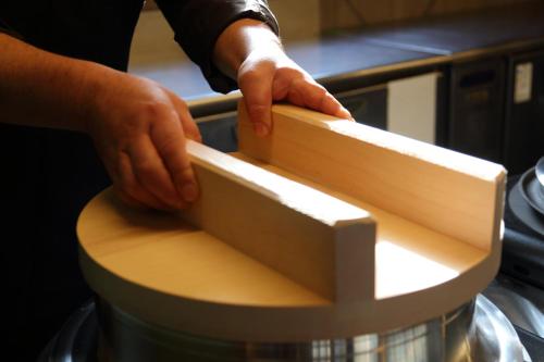 a person cutting a piece of wood with their hands at Hotel Angel Grandia Echigo Nakazato in Yuzawa