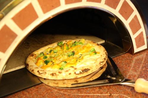 a pizza is being cooked in a toaster oven at Hotel Angel Grandia Echigo Nakazato in Yuzawa