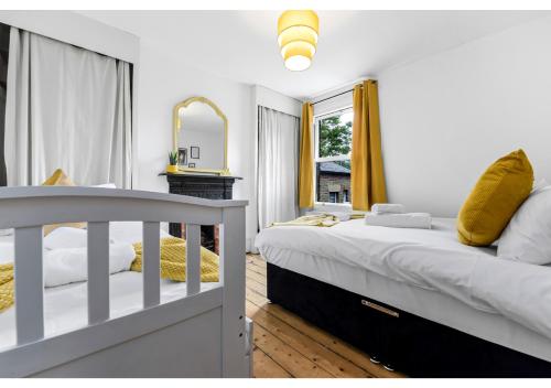 a white bedroom with a bed and a mirror at Handsome Family Home Peaceful, Next to Park in London