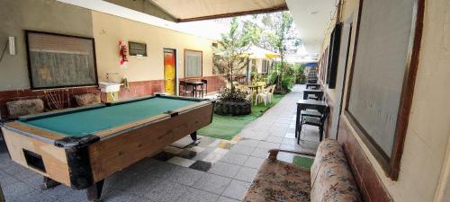 a pool table in the middle of a room at Hostel Megaró in Santa Teresita