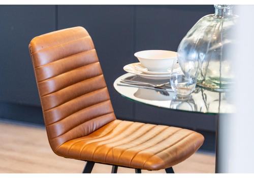 a chair with a table with a cup and a plate at Beckenham Beauty: Modern 1-Bedroom Abode in Beckenham