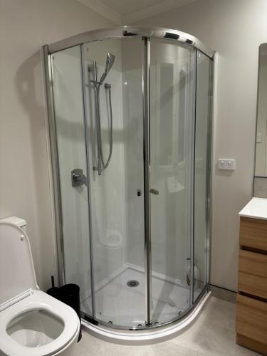 a shower stall in a bathroom with a toilet at Hamilton New Town House in Hamilton
