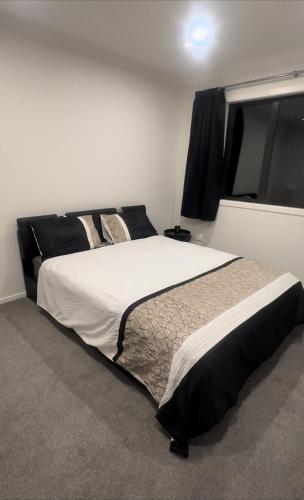 a bedroom with a large bed and a window at Hamilton New Town House in Hamilton
