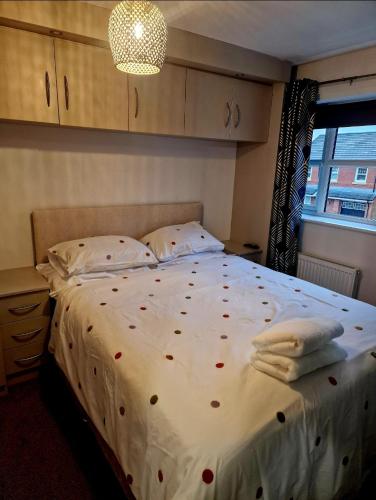 Un dormitorio con una cama con corazones rojos. en Well Furnished 3 Bedroom House in a cosy estate in Bolton, en Bolton
