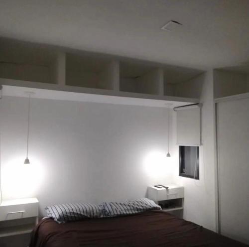 1 dormitorio con 1 cama con 2 luces encendidas en Casa container con pileta a 4 cuadras de la playa en Quequén