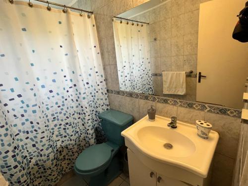 een badkamer met een blauw toilet en een wastafel bij Casa Colibrí - Tongoy in Tongoy