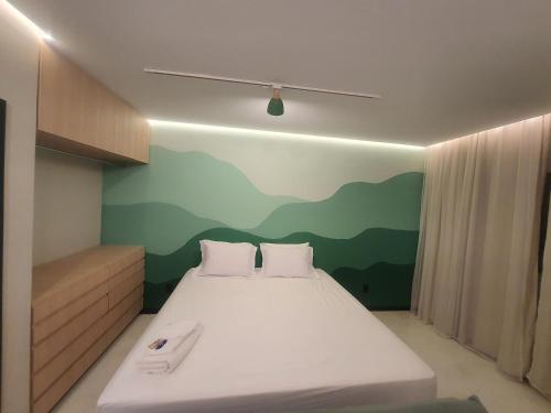 a bedroom with a bed with a mountain mural on the wall at Theotokos Flats Apart-hotel in Piumhi