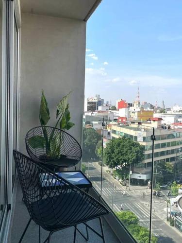 a balcony with a chair and a view of a city at depto con alberca zona condesa in Mexico City