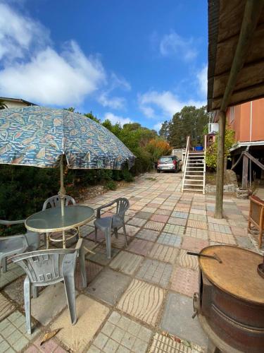 埃爾基斯科的住宿－CABAÑA EL QUISCO，庭院配有桌椅和遮阳伞。